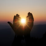 faith of christian concept: spiritual prayer hands over sun shin